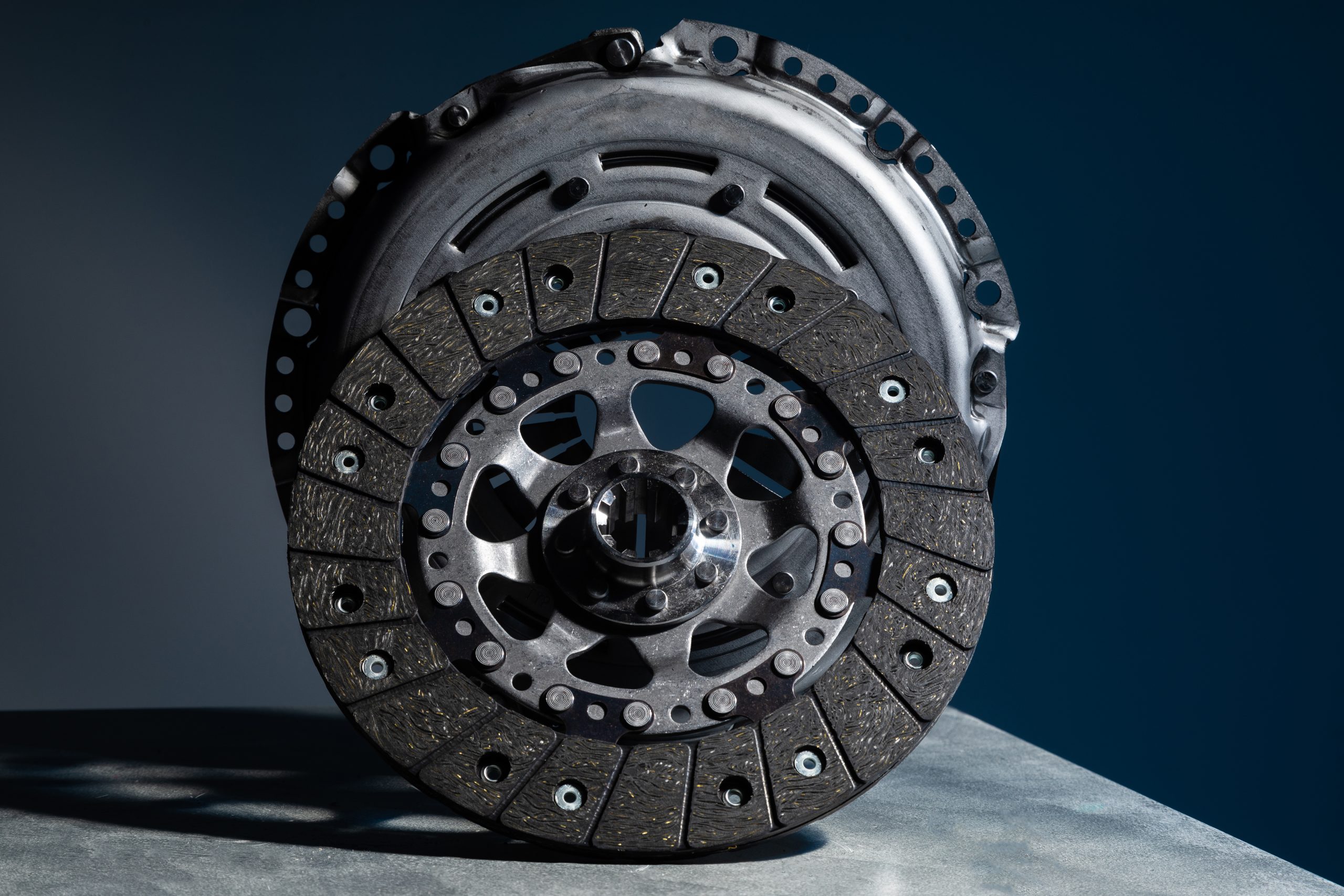 Close-up picture of a part of car, black clutch disk isolated on black background.